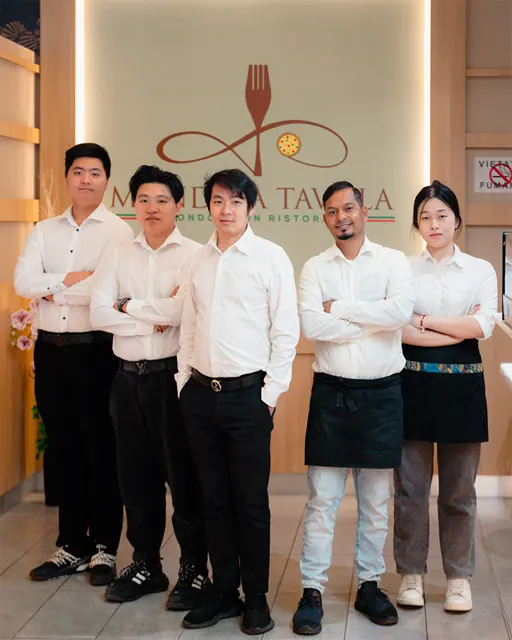 Il team di Mondo a Tavola davanti al logo del ristorante
